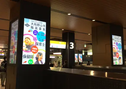 駅に掲出された職員募集のデジタルサイネージ